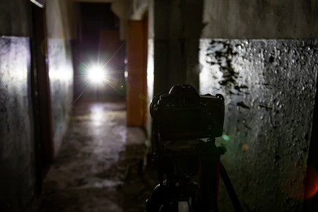 Camera on tripod in dark abandoned building. Urban exploration concept.の写真素材