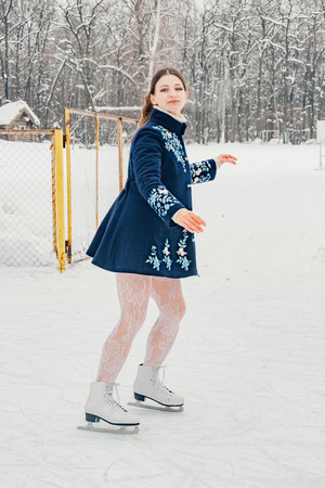 Young skating woman on snowy winter day.の写真素材