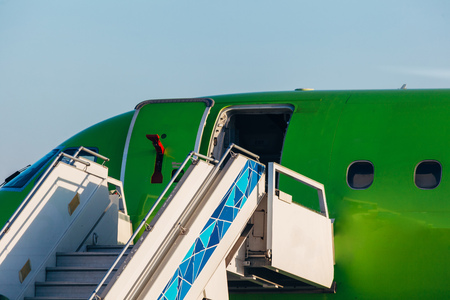 Opened passenger airplane door with attached ladder, close upの写真素材