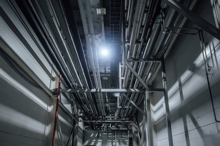 Heating or cooling water pipes on ceiling of industrial or office building.の写真素材