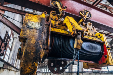 Old rusty hoist of Industrial overhead crane in factory. Close up.