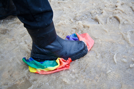 Trampling of LGBT flag in dirt by radical homophobe.の写真素材