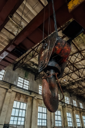 Old rusty crane hook inside industrial building.の写真素材