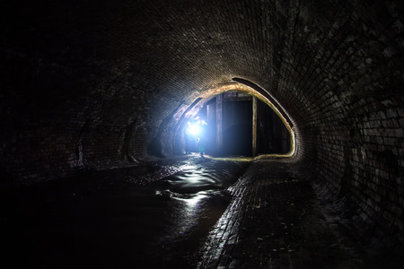 Old vaulted sewer tunnel with dirty sewage water. Underground river Neglinnaya flowing under Moscow.の写真素材