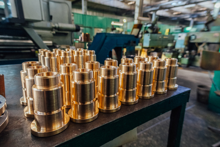 New brass threaded bushings on table in factory.の写真素材