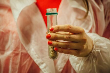 Female brewery worker hands holding malt samples in test tubes.の写真素材