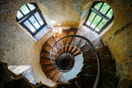 Old spiral staircase in abandoned mansion, upside view.の写真素材
