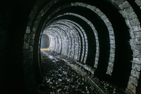 Dark dirty abandoned uranium mine with rusty remnants of railway.の写真素材