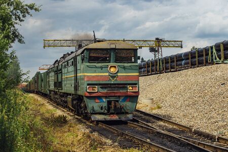Old green diesel locomotive moving cargo train.の写真素材
