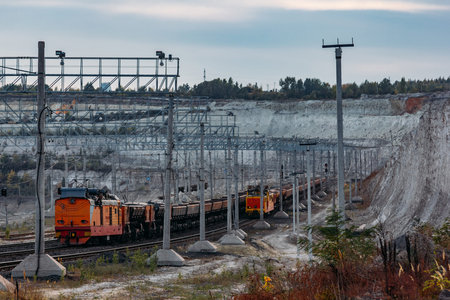 Freight train with ore in open mining quarry.