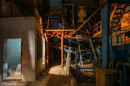 Abandoned brick and paving slabs factory at night. Old rusty machinery.