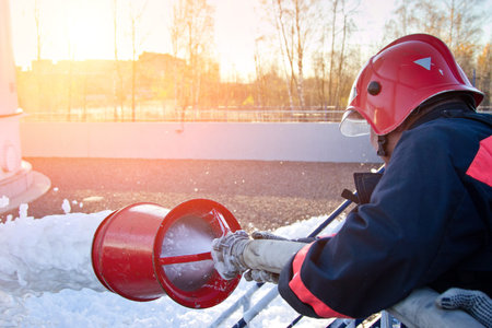 Fireman extinguish fire by foam spraying hose.