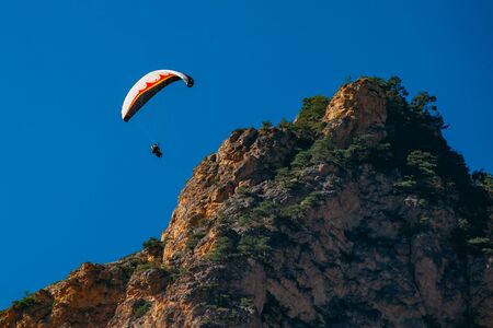 Flying of paraglider above autumn rocky mountains.の写真素材