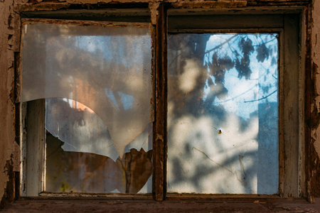 Broken window of old abandoned wooden building.