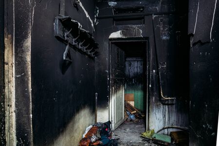 Consequences of fire. Burnt house interior. Charred walls and ceiling in black soot.の写真素材