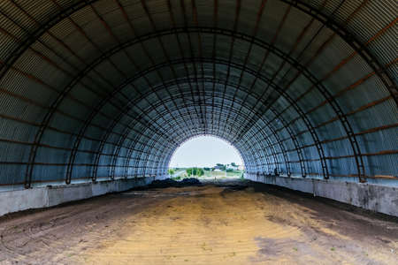 Old empty abandoned rusty metal arched hangar.の写真素材