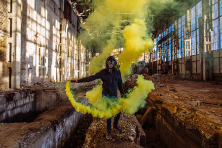 Person in gas mask with smoke in abandoned industrial building.の写真素材