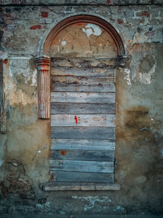 Wall of abandoned building with broken boarded up windows.の写真素材