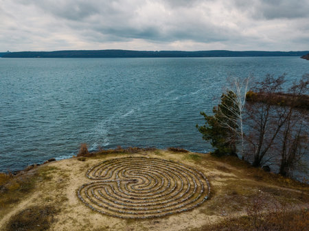 Spiral labyrinth made of stones on the coast, aerial view.