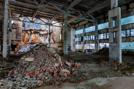 Abandoned ruined large industrial hall with garbage waiting for demolition.
