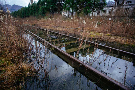 Old rusty flooded railway in abandoned industrial area.の写真素材