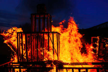 Burning wooden building at night, close up view.の写真素材