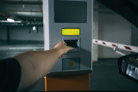 Man in car pays for underground parking using payment terminal.