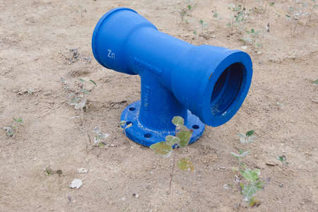 Cast metal pipe T shape connection with flange on the sand.の写真素材