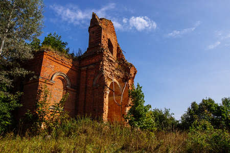 Old ancient abandoned church ruins overgrown by plants.の写真素材