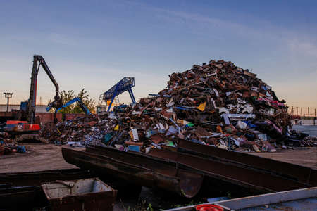 Metal recycling industry. Gripper excavator working on a scrap yard.の写真素材