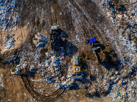 Garbage dump and working dump truck and bulldozer, aerial top view.の写真素材