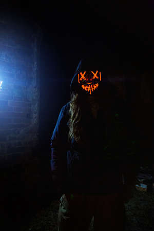 Man in creepy glowing mask in abandoned building. Horror concept.の写真素材