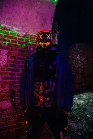 Man in creepy glowing mask in abandoned building. Horror concept.の写真素材