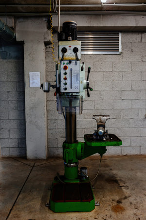 Industrial drilling machine tools in metalwork factory workshop.