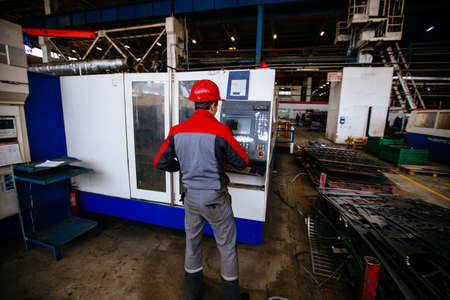 Operator works with CNC laser cutting machineの写真素材