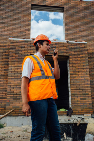 Construction worker in the helmet speaks on the radio