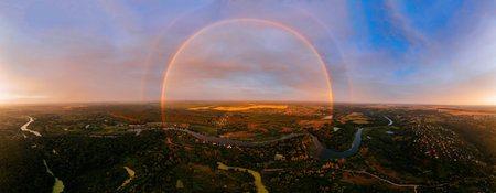 Round rainbow over the river on a summer evening