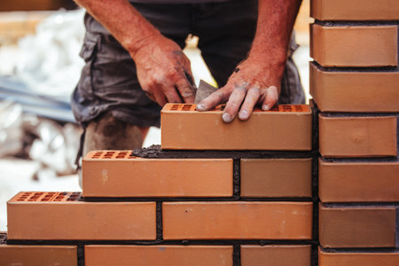 Builder laying bricks on construction siteの写真素材