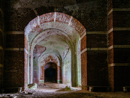 Dark corridor of old ancient abandoned red brick ruined historical building.