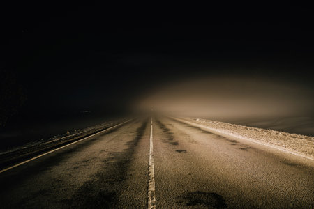 Foggy misty road at nightの写真素材