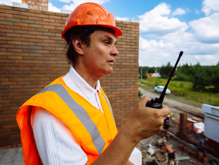 Construction worker in the helmet speaks on the radioの写真素材
