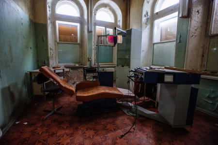 Old broken dentist chair in abandoned dental clinic.の写真素材
