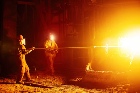 Metallurgists taking samples of liquid molten metal.の写真素材