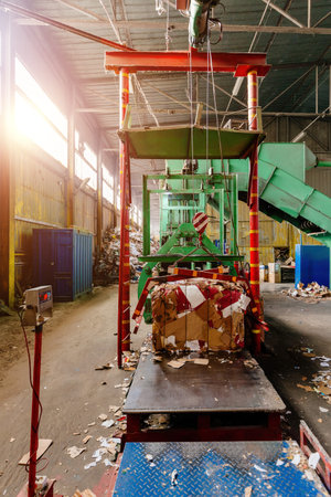 Pressing and baling of wastepaper in recycling factory.