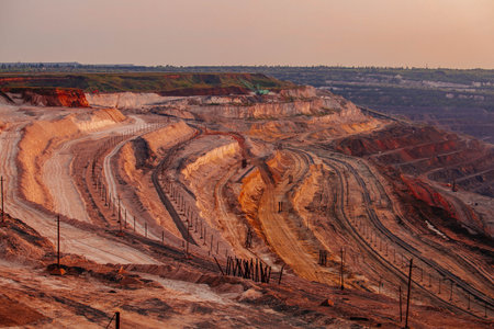 Excavators and dump trucks working on earthmoving at open pit mine in mining and processing plant.