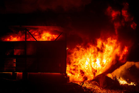 Exploding warehouse. Burning industrial building. Big blaze at night.
