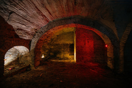 Dark and creepy vaulted red brick cellar under old castle.の写真素材