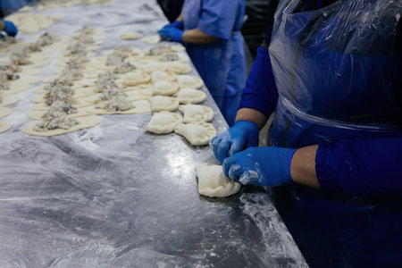 Baker kneading dough and making pies at bakery