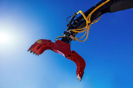 Modern crane arm with open grapple, industrial gripper.の写真素材