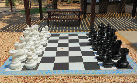 Chessboard with huge black and white chess figures for outdoor playing. Nice backgroundsの写真素材